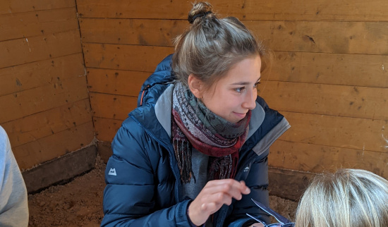 Sabrina Selinger zeigt den Kindern, wie man eine Rauchschwalbe bastelt Foto: Berit Künzelmann